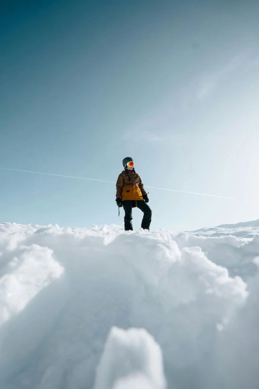 a snow boarder sitting on the top of a hill