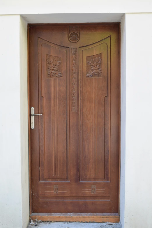 two wooden doors in front of a wall