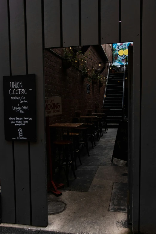 an open door to a bar on a narrow alleyway