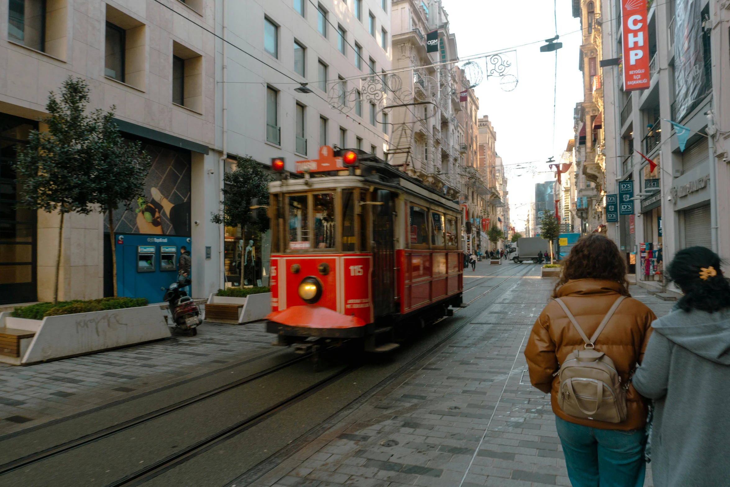 two people walking near a trolley on a street