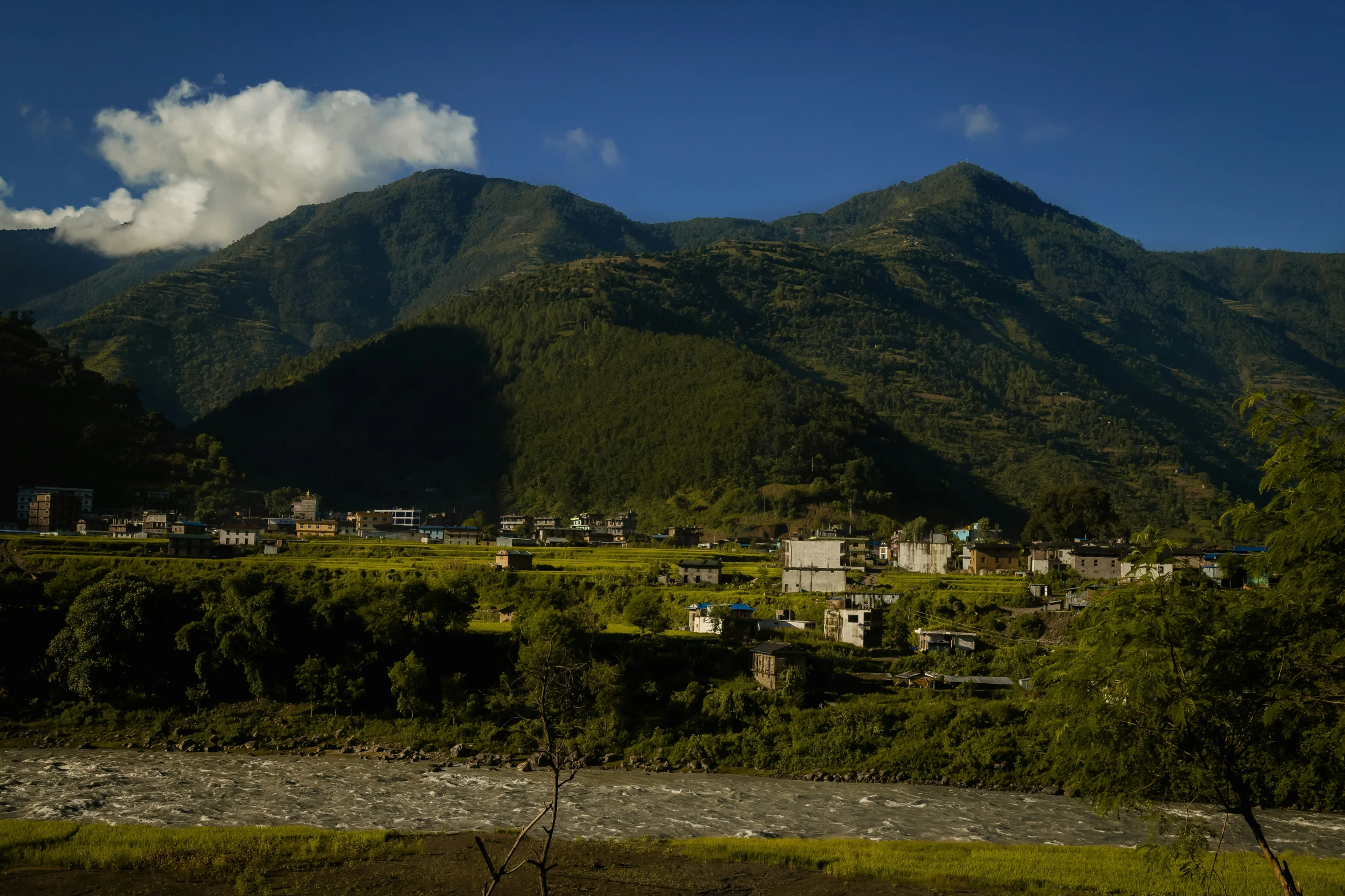 a village sitting among some lush green mountains