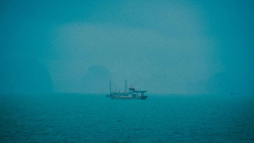 a boat is sitting out in the ocean alone