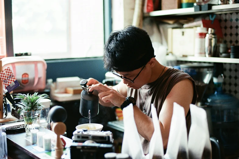 a man doing crafts in the kitchen while holding scissors