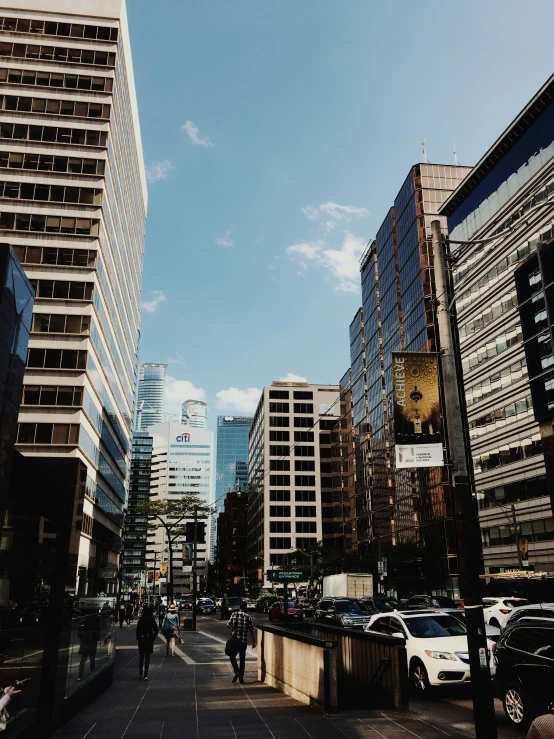 a wide street surrounded by buildings and people walking