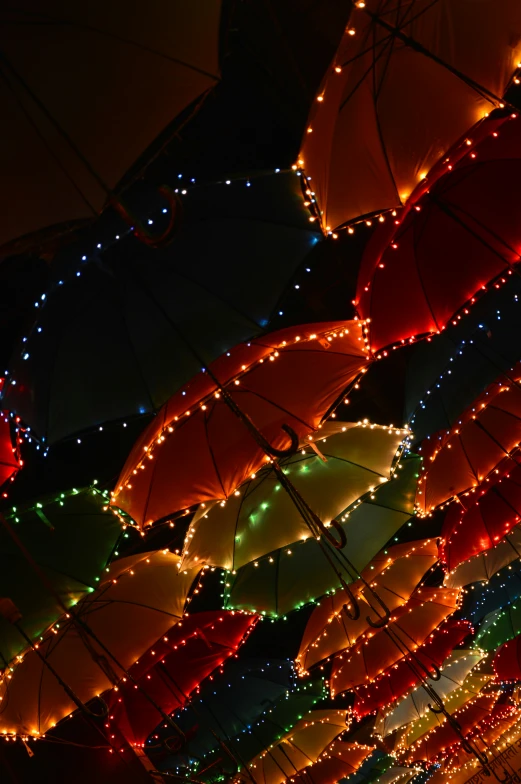 lots of colorful lights all over umbrellas lit up