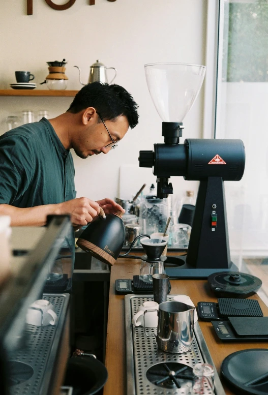 a man pouring soing into a small cup