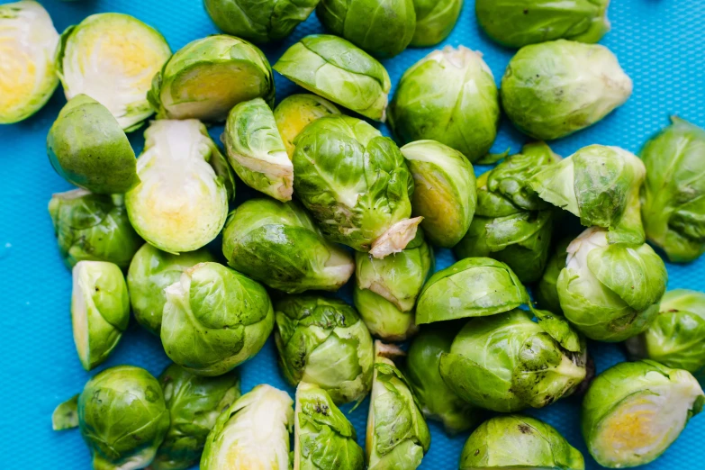 a pile of brussel sprouts on a blue table