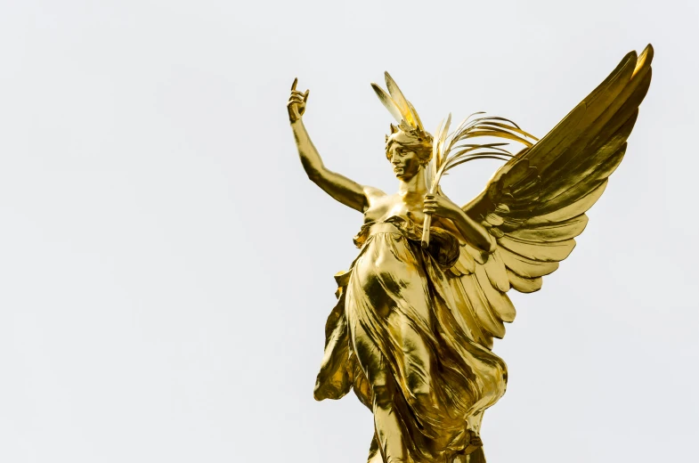 a gold statue of an angel with wings