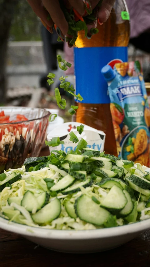 a bowl of zucchini pasta is being cooked on a wooden table