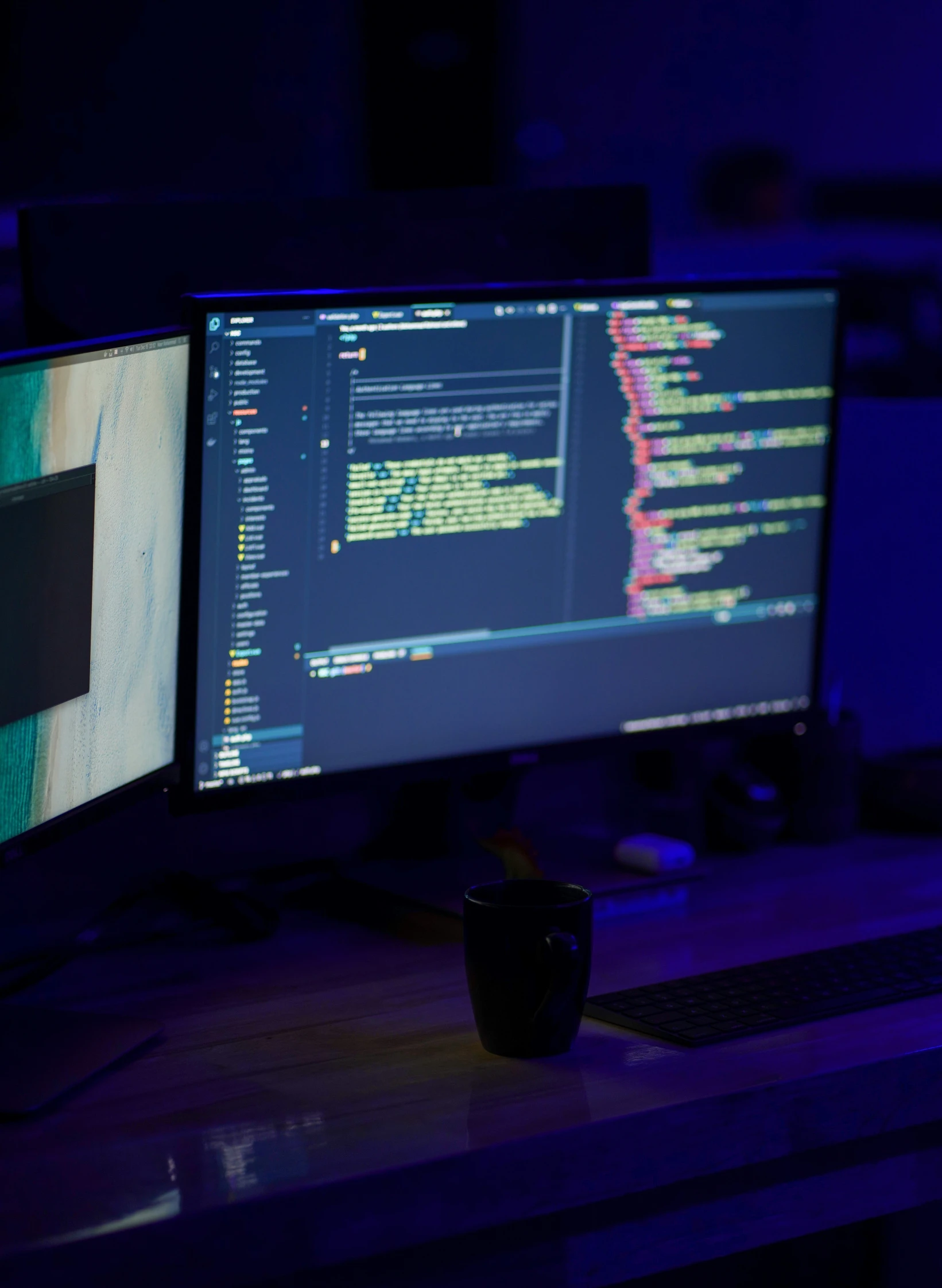 a desktop with dark lighting and various screens on it