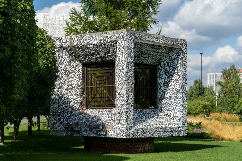 a small sculpture sitting in the middle of a lush green park