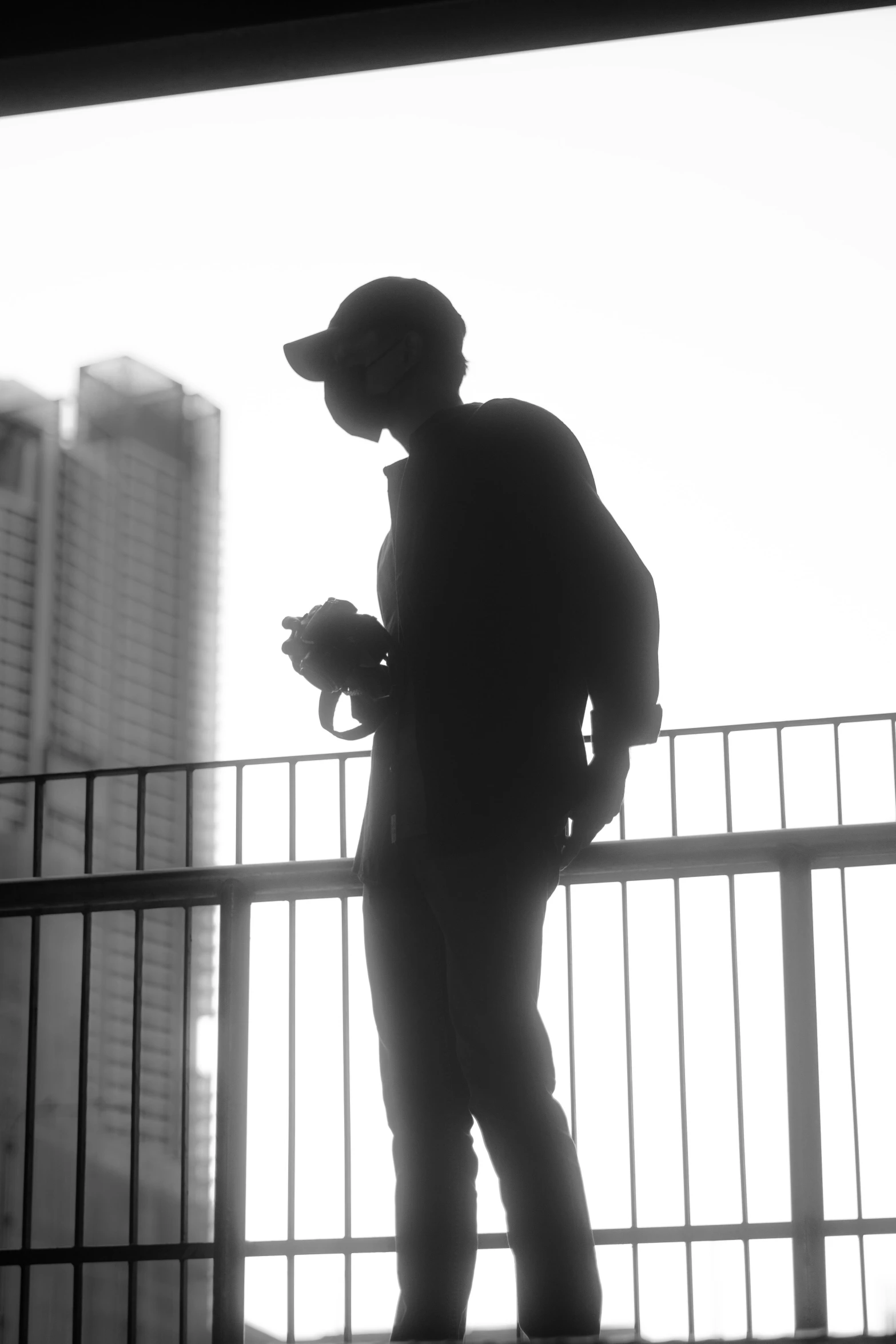 a person standing on a bridge by a fence