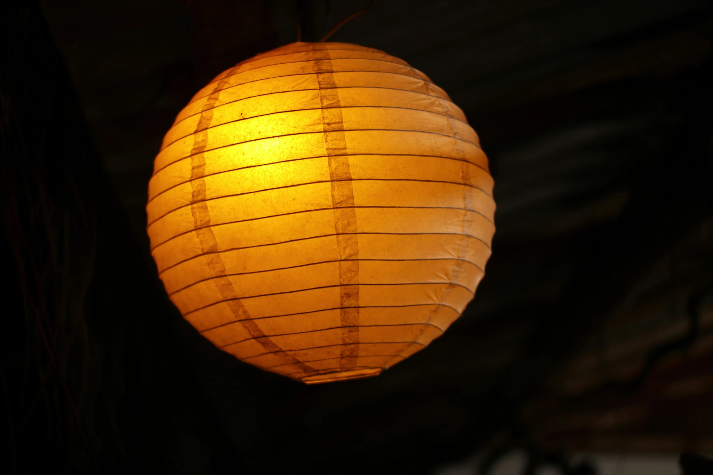 an asian style lantern light hanging from the ceiling