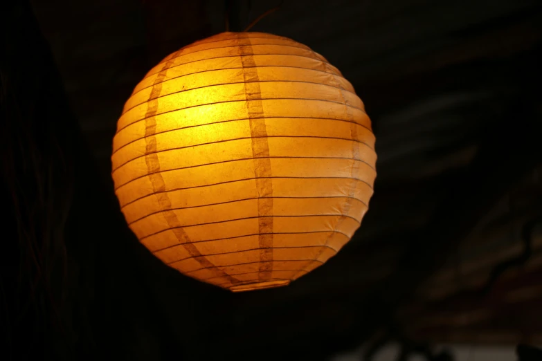 an asian style lantern light hanging from the ceiling