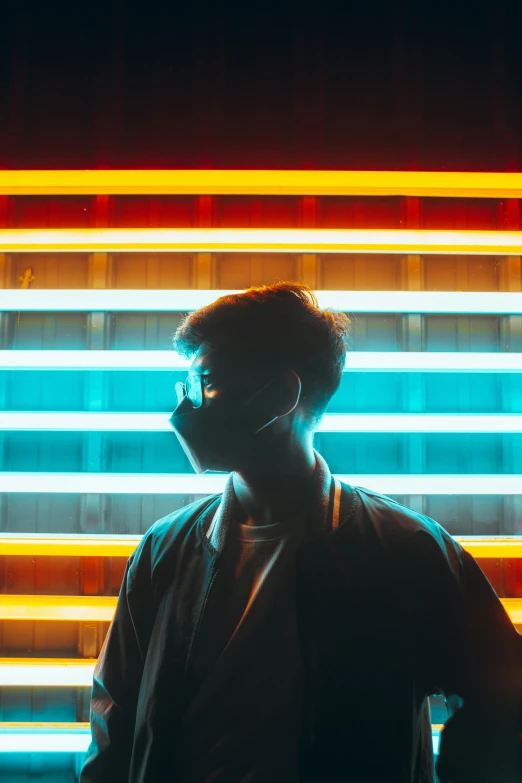 a man standing next to a building with a long neon fence in front of him