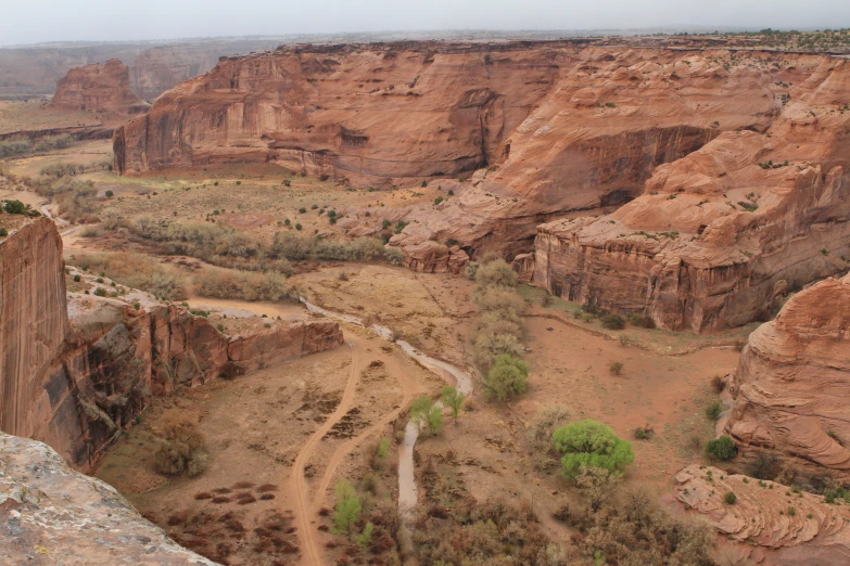 a dirt road through a canyon near many rocky mountains