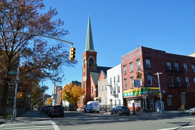 a building with a steeple stands in the middle of a city street