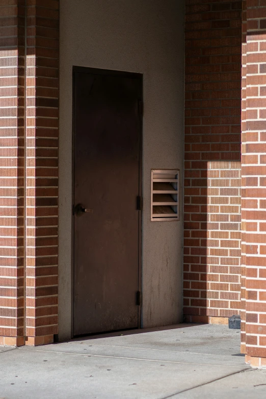 a door and brick building with sunlight shining on it