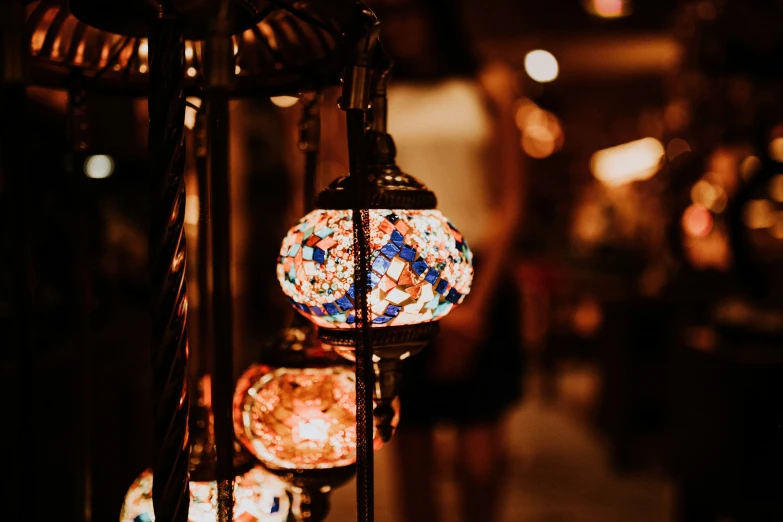 three hanging glass globes next to each other on an antique metal stand