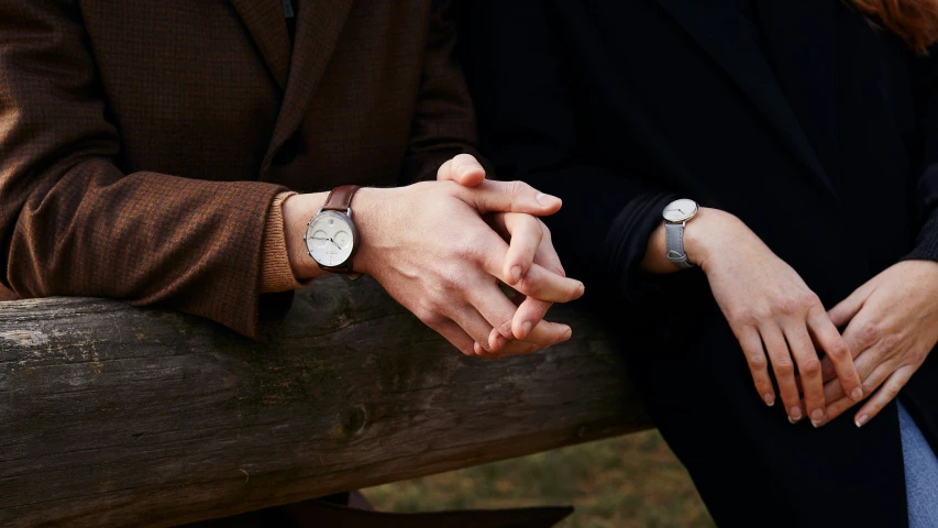 a woman's hands holding the wrist of a man's hand