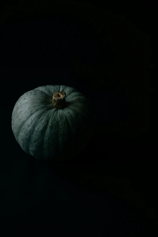 a small, green pumpkin sitting on top of a table