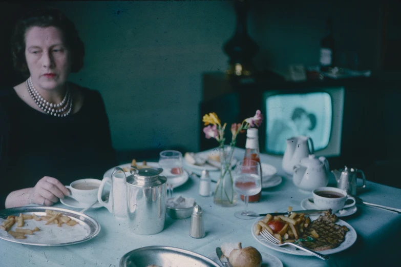 a woman in black dress sitting at a dinner table