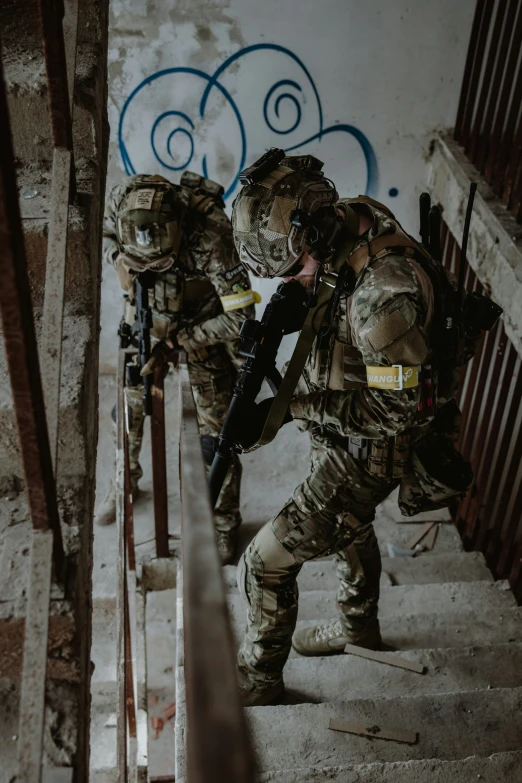 a soldier is climbing up some stairs while wearing full gear