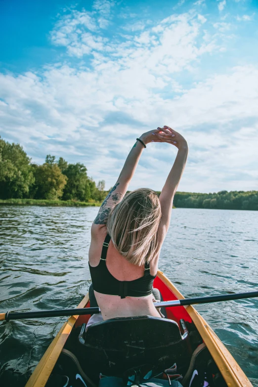 a woman rowing in a canoe on a lake