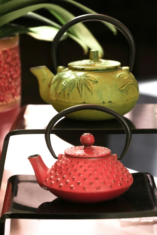 a red tea kettle sitting on a plate