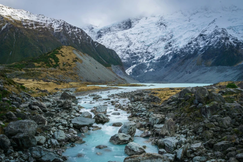 a mountain landscape with water and snow covered mountains