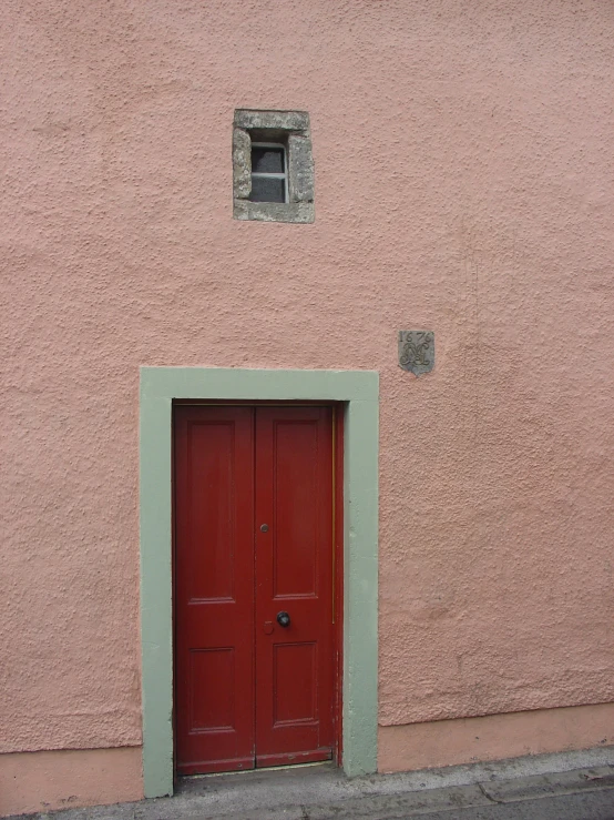 red door with green trim in front of the wall