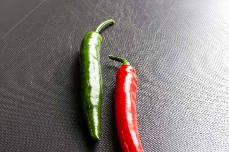 two peppers sitting on top of a surface