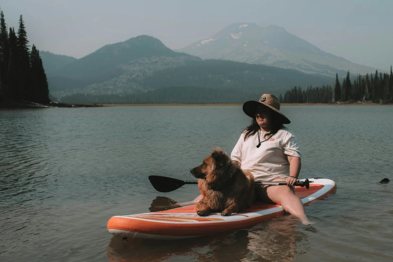 a woman on a kayak with her dog