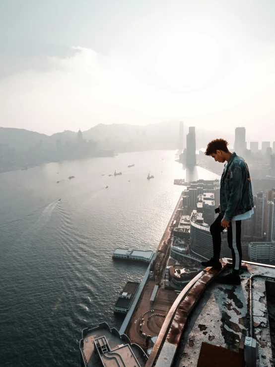 a man standing on top of a tall building near the ocean