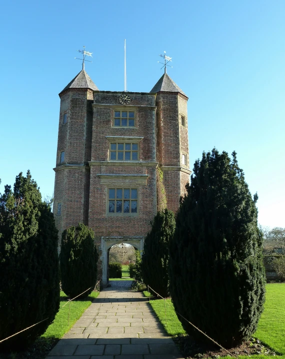 an elaborate brick building with towers and chimneys on each corner