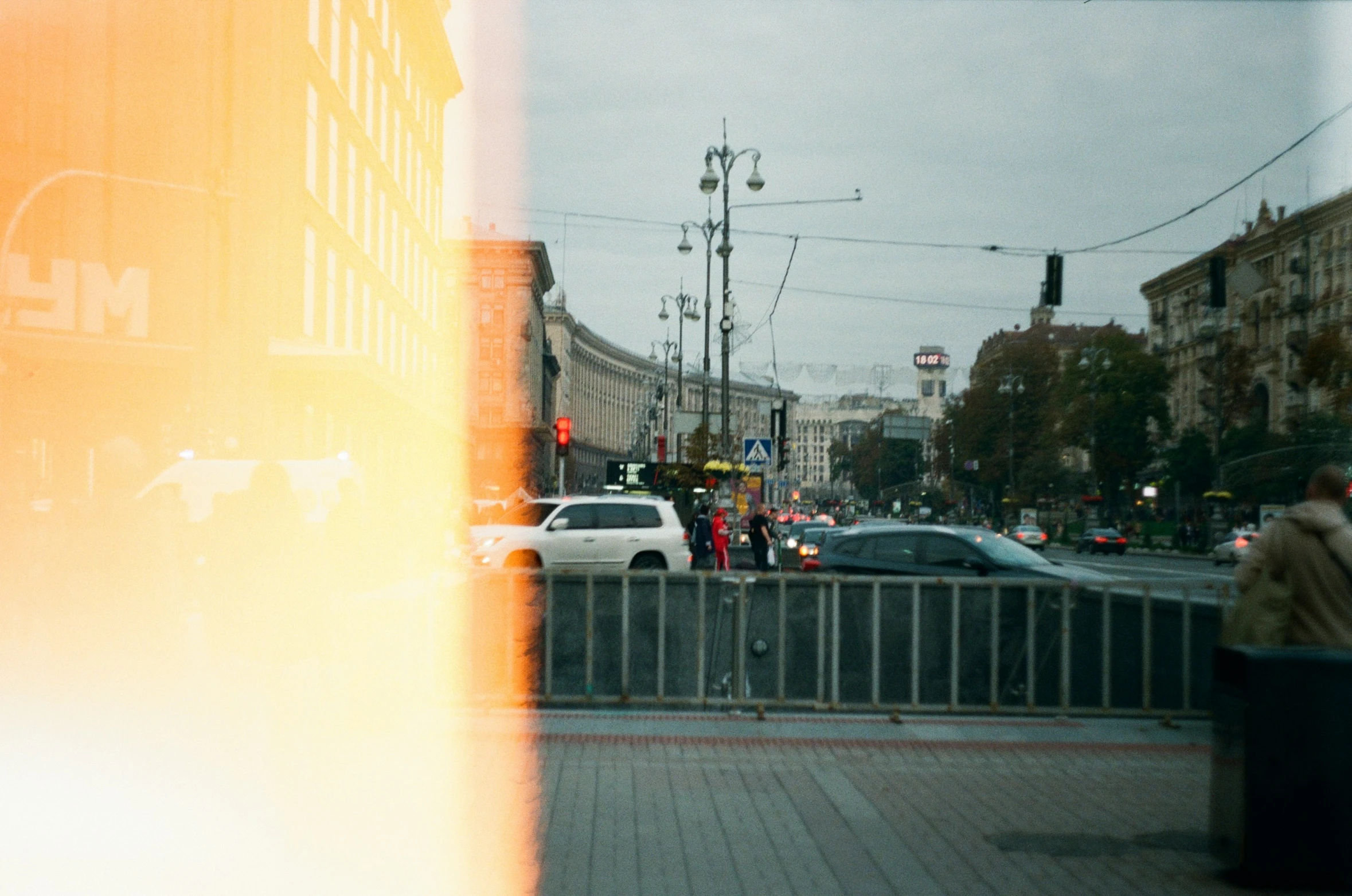 the view out a window from a street with cars and people