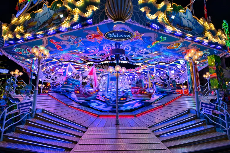 a very colorful christmas carousel at night decorated