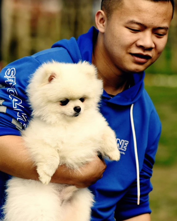 a man holding a little dog in his arms