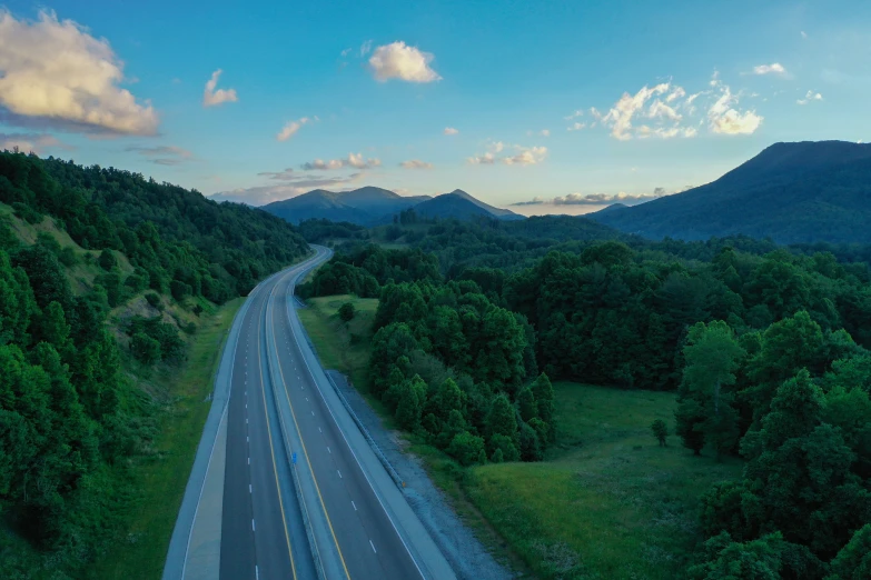 a long highway passing through a lush green countryside