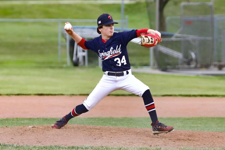 a boy is in mid throw throwing a baseball