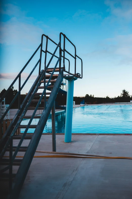 blue swimming pool and staircase leading to the top of the pool