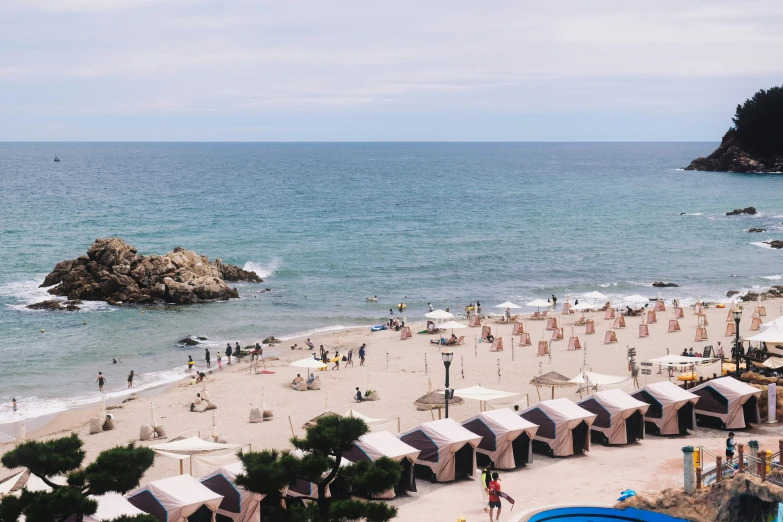 an open air beach area with many people and blue waters