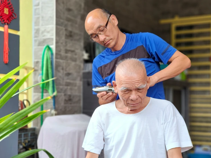 an elderly gentleman standing next to another man