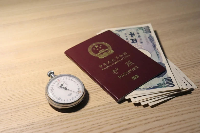a watch, passport and money are on a table