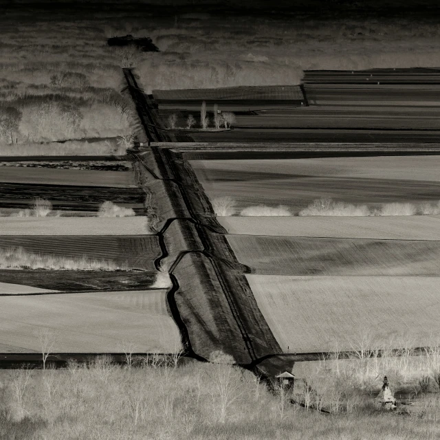 a black and white po of a fence in an open field