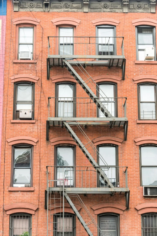 a large brick building with a metal staircase leading to two floors