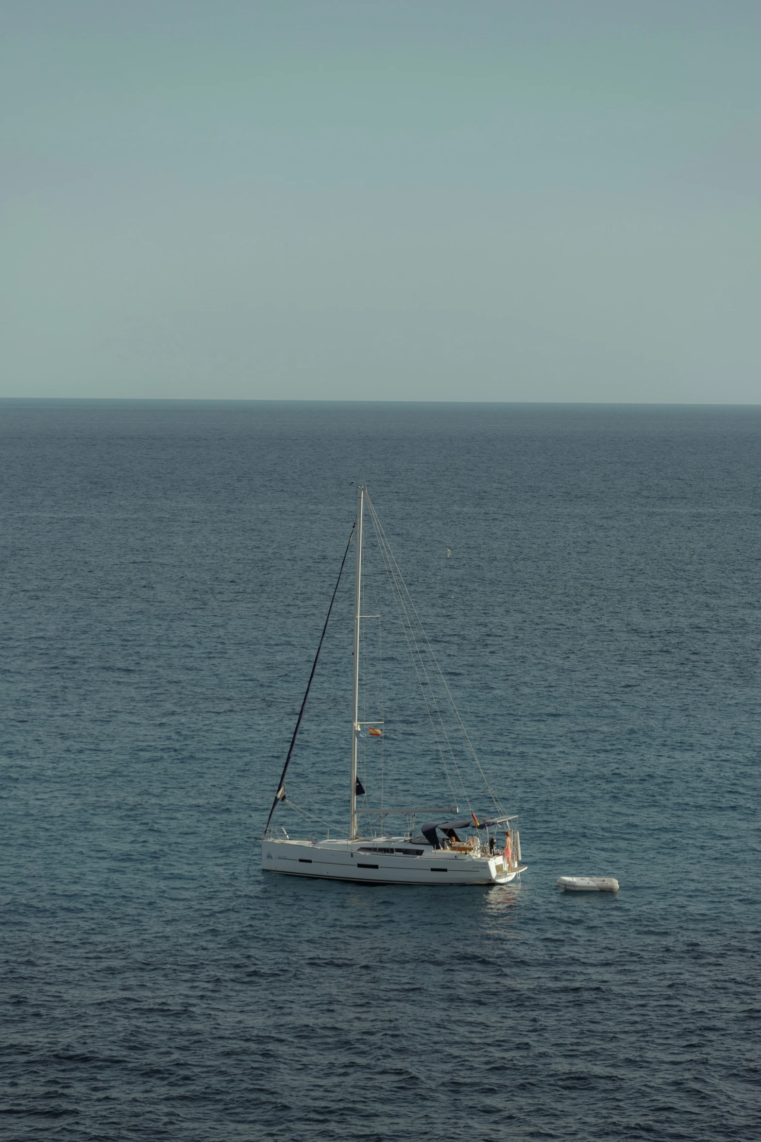 a sailboat on the open water with the sails down