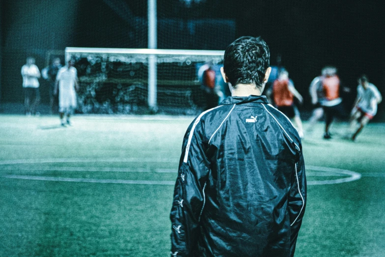 man watching a soccer game in the dark