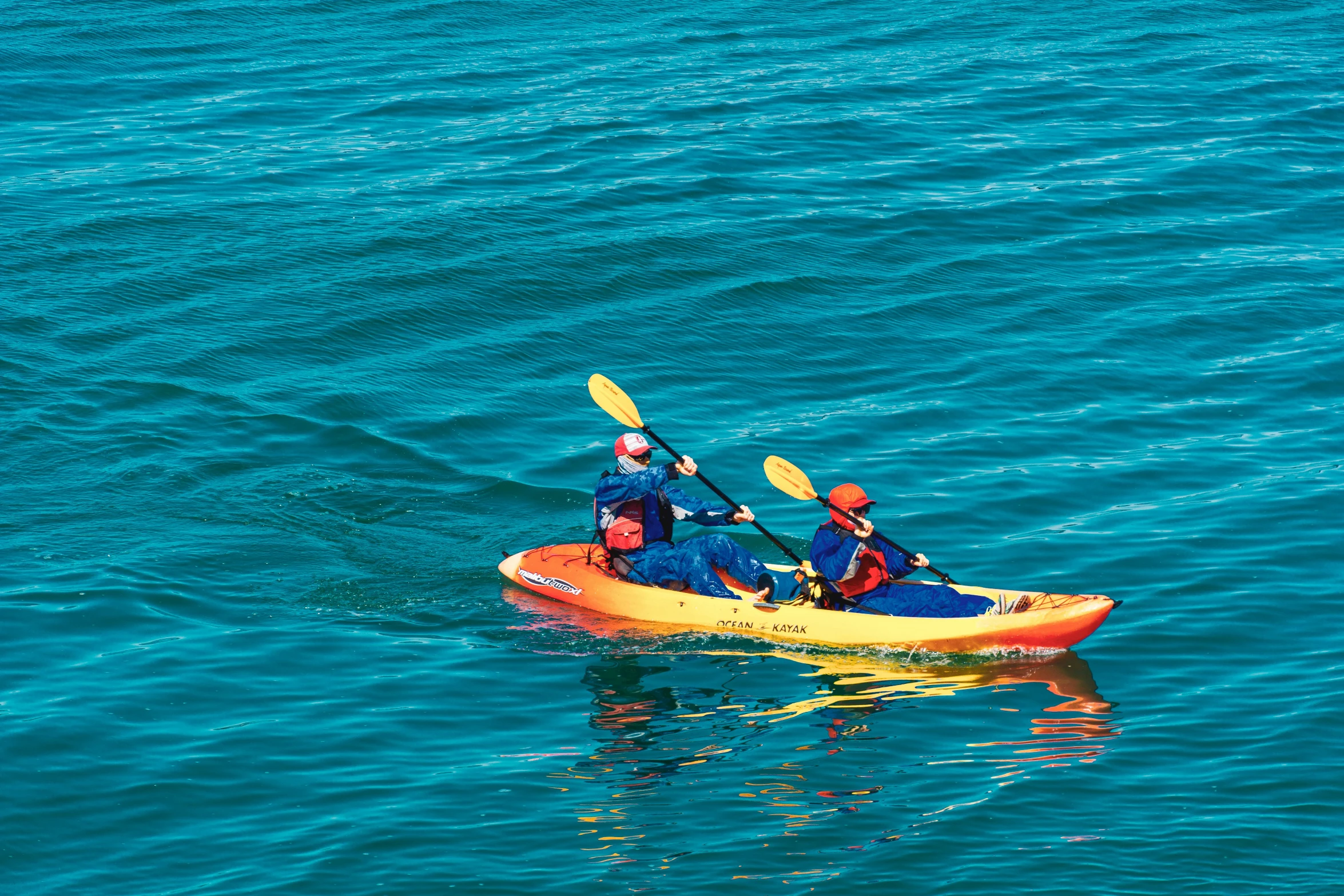 two people in a kayak on blue water