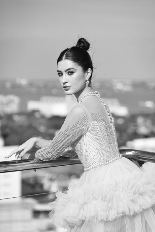 a black and white image of a woman leaning on a balcony rail